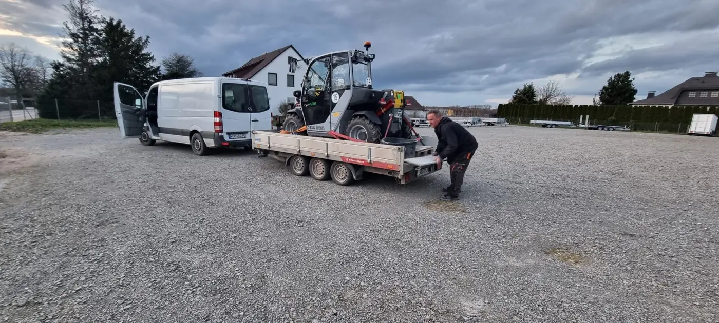 Transporter von JK-Gebäudemanagement mit Baggeranhänger