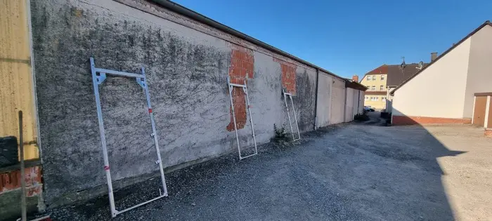 Verwitterte Hofwand vor der Sanierung